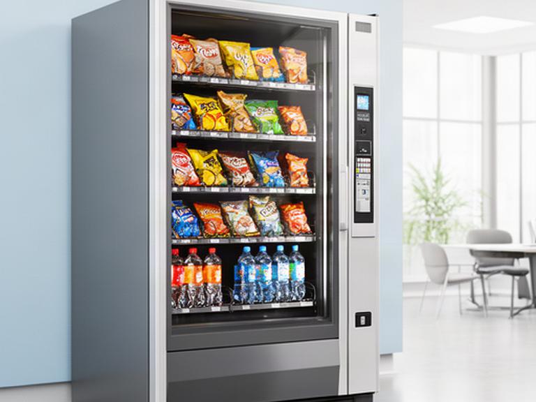 Distributore automatico moderno con snack e bevande in un ufficio luminoso